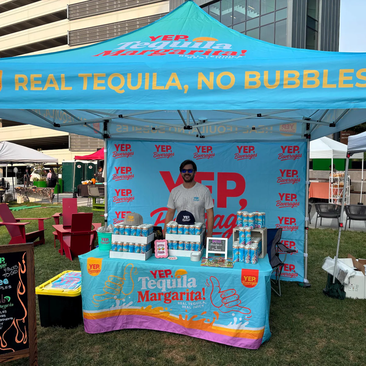 Blue custom printed canopy tent with branded backwall and fitted table cover at a beverage sampling event
